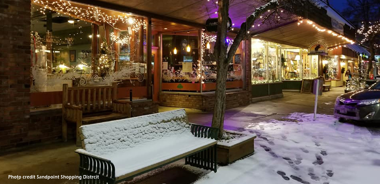 view of snowy first ave in sandpoint with holiday lights