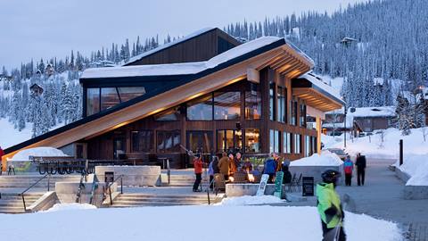 Skiers sitting around the fire on the Crow's Bench patio