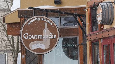 Outdoor Gourmandie signage with light snow falling