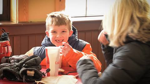 A young guest happily eats lunch at Lakeview Cafe