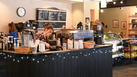 Interior of Mojo Coyote Cafe with baristas making espresso drinks