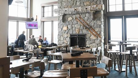 Interior of The Nest restaurant with tables and stone fireplace