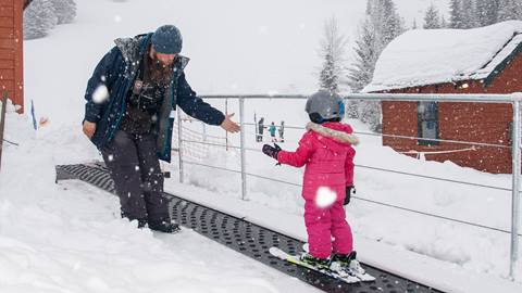 Lift operator giving high fives and fist bumps on the Musical Carpet at Schweitzer. 