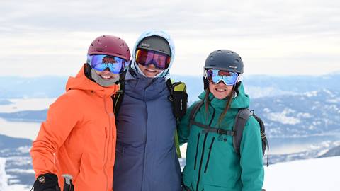 Three skier friends smiling. 