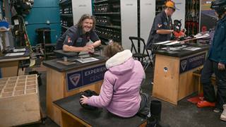 Schweitzer Ski Technician helping a guest with rental boots and skis.  