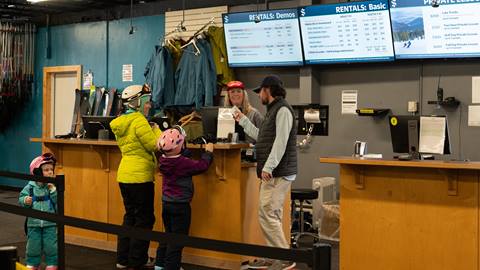 Family standing at the Rental Desk at Schweitzer. 