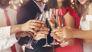 four people at a party toasting Champaign glasses.