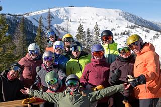 A group of skiers with a view of the Outback Bowl at Schweitzer's Rowdy Grouse