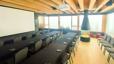 Glass Room at Schweitzer's Humbird hotel set up for a meeting with long tables and big screen projector