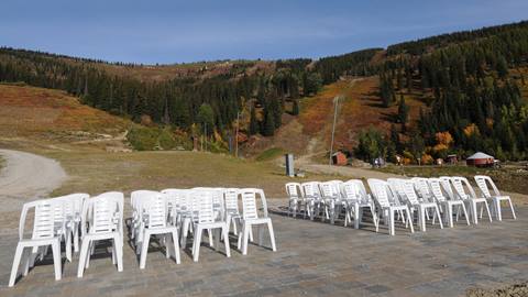 Chairs set up on Creekside Express Patio with a view of Schweitzer slopes in the background.