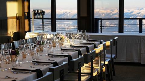 Long table set up for a group dinner in Sky House Nest at the summit of Schweitzer