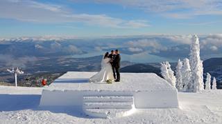 Bride and Groom standing at the summit of Schweitzer