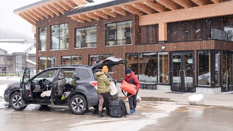 Image of guests unloading their car in the parking lot