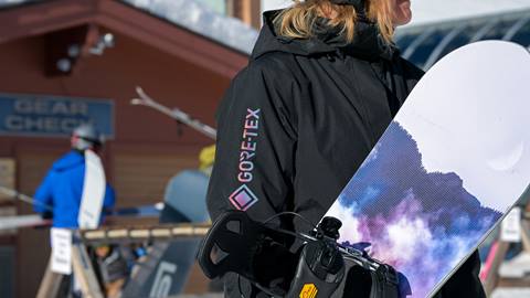 person holding snowboard in black jacket