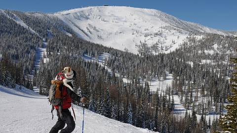 Schweitzer Ski Patrol and Avy Dog standing in front of a view of the Outback Bowl. 