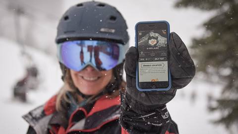 Schweitzer Ski Patrol holding a phone with the AirFlare app open on the screen