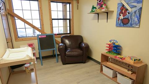 infant care room with seating and toys