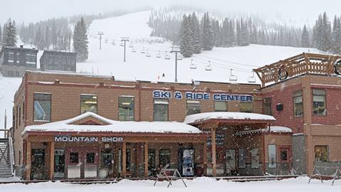 Snowy exterior shot of the ski and ride center building.