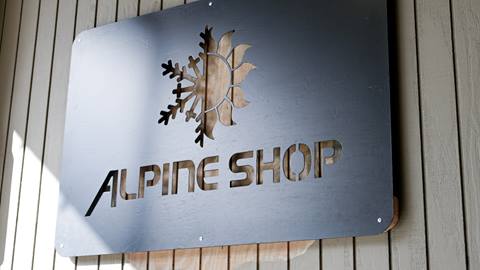 Metal sign hanging outside Alpine Shop at Schweitzer