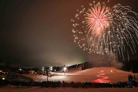 ski run at night with red fireworks 