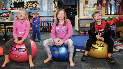 kids playing on bouncy balls and making silly faces