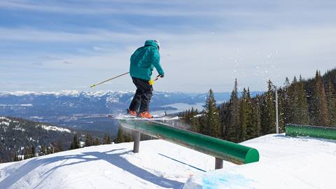 Skier sliding a flat rail in the terrain park at Schweitzer